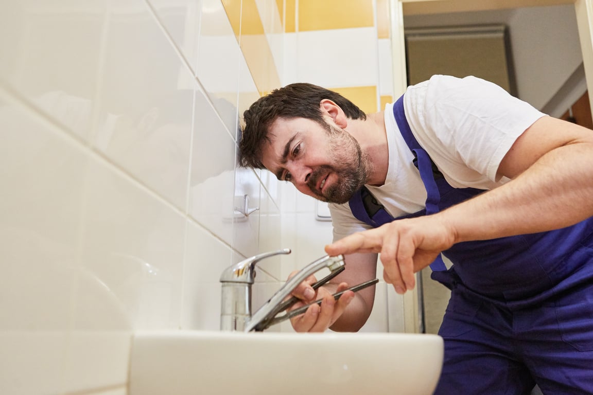 Plumber Repairs Broken Faucet in the Bathroom